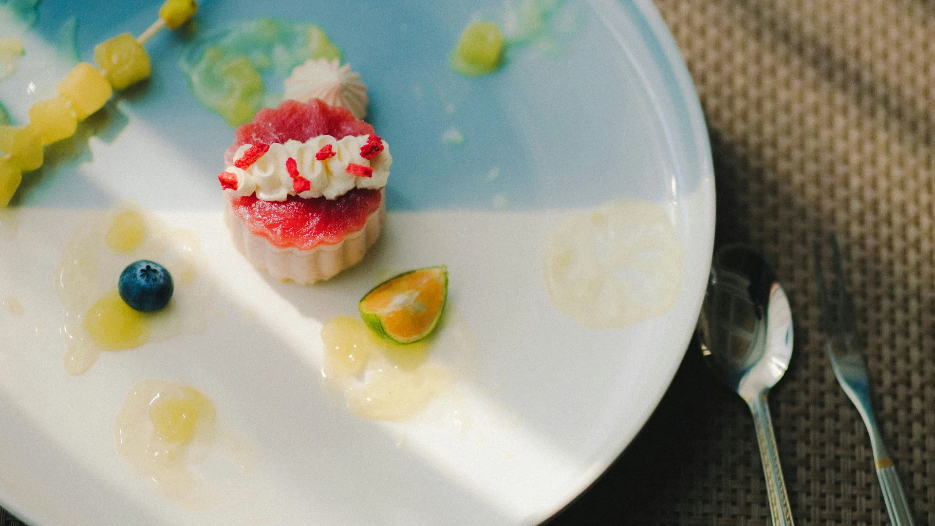 Bilder aus dem DASEYN Kleines Dessert mit roter Creme und Sahne auf blauem Teller