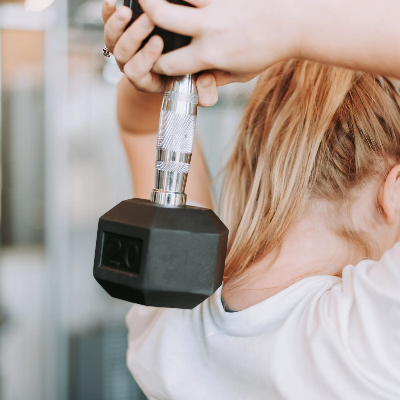 Auf ins Gym in Berlin-Mitte Blonde Frau hebt eine Hantel im Fitnessstudio