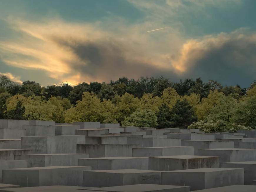 Berliner Sehenswürdigkeiten Sonnenuntergang über dem Holocaust-Mahnmal mit Bäumen im Hintergrund