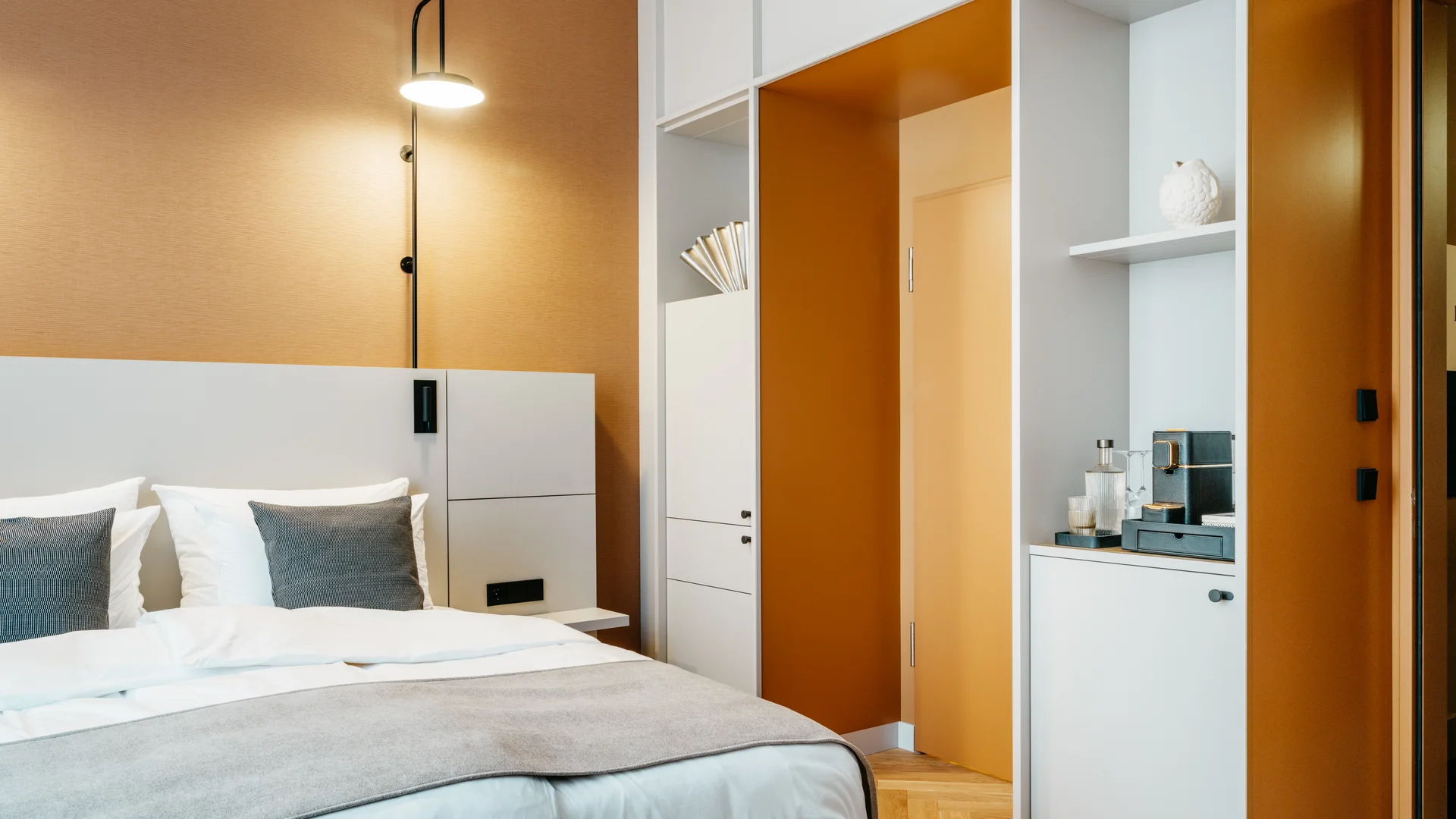 Bilder aus dem DASEYN Modernes Schlafzimmer mit weißen Möbeln und orangefarbenen Wänden