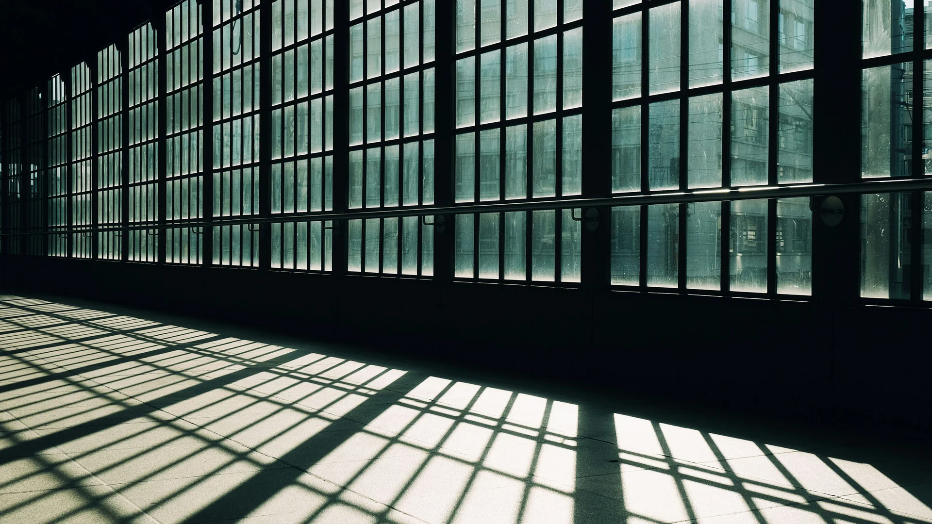 Ihre Presse- und Medienanfragen an das DASEYN Große Fenster mit Schatten auf dem Boden in einem dunklen Raum