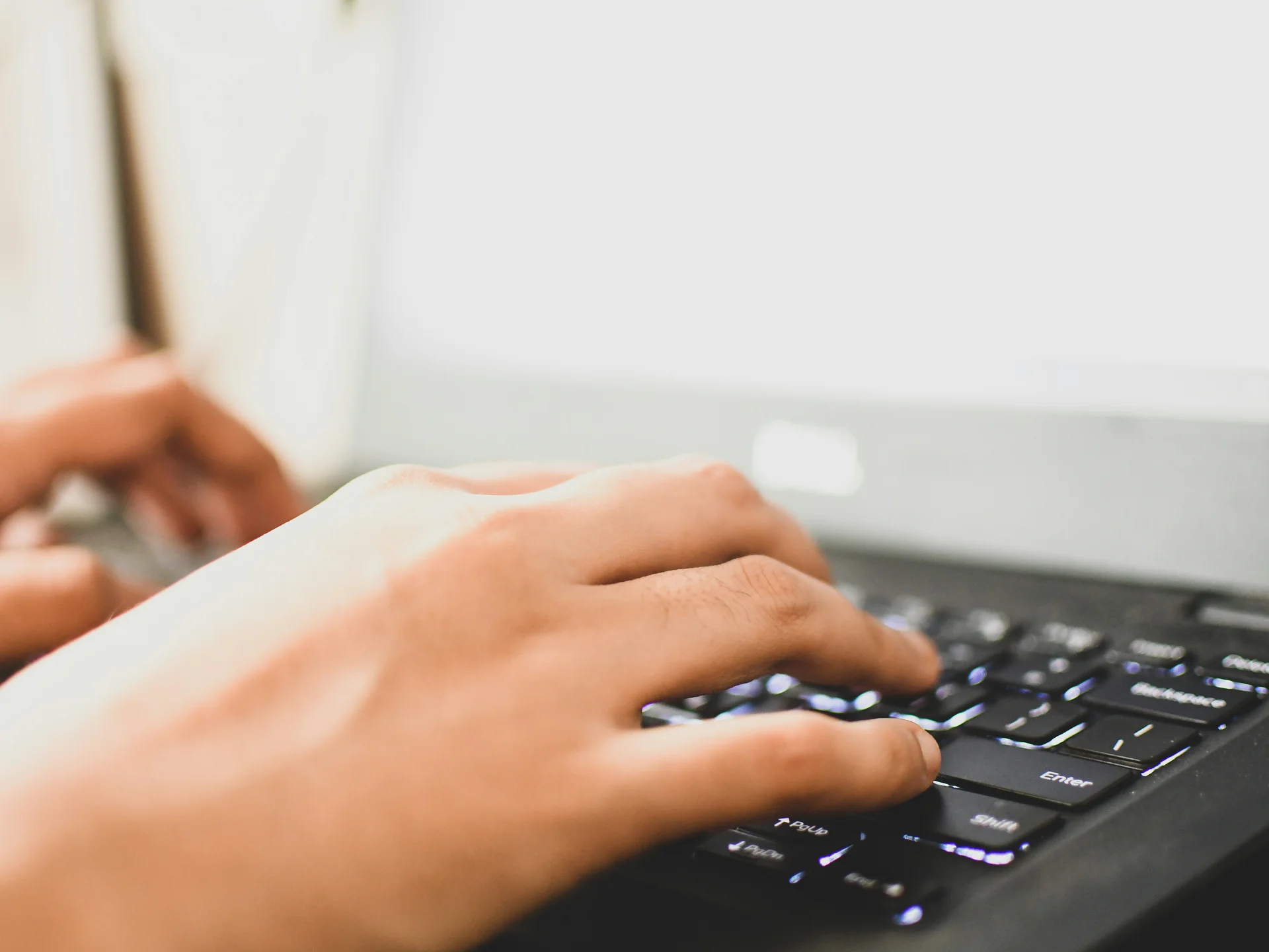Director of Sales & Convention Sales Hände tippen auf einer schwarzen Laptop-Tastatur